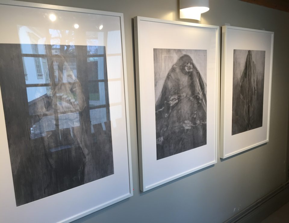 Fotografi på inramade teckningar från en konstutställning.