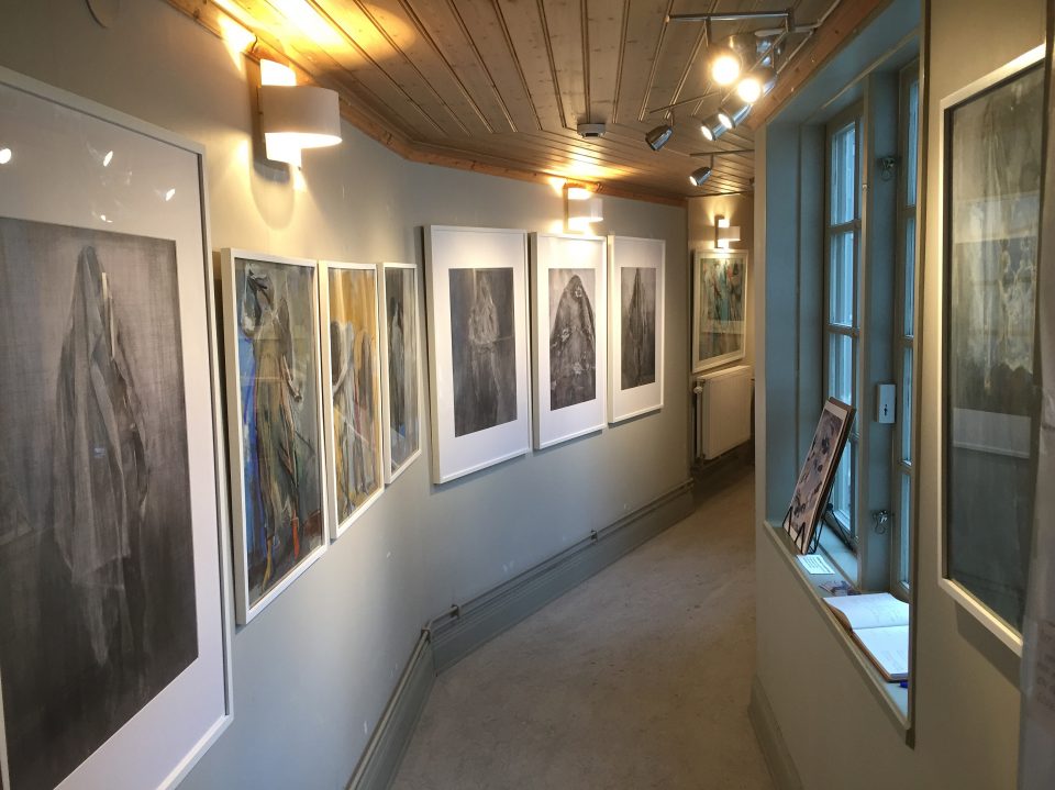 Fotografi på inramade teckningar från en konstutställning.